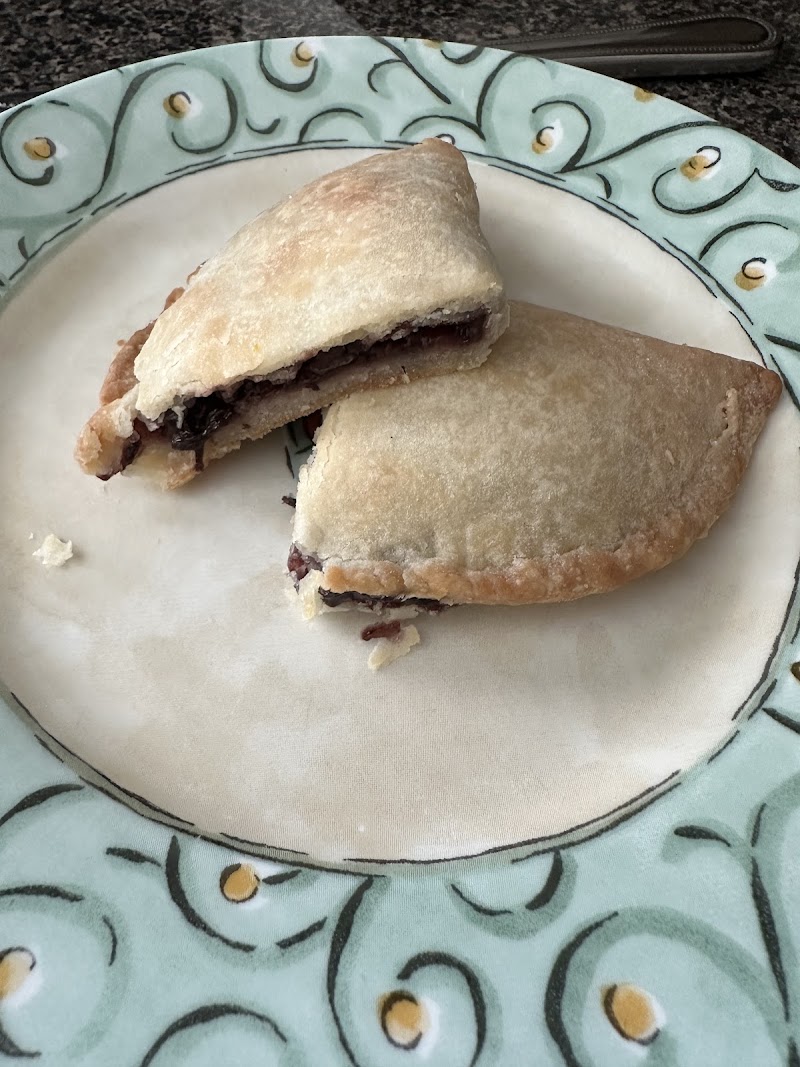 Handcrafted fried pie cut in half on a decorative plate at Deb's Delights Bakery