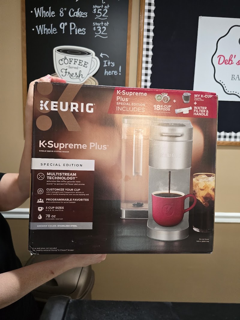 Inside Deb's Delights Bakery showing fresh coffee and chalkboard menu with pricing